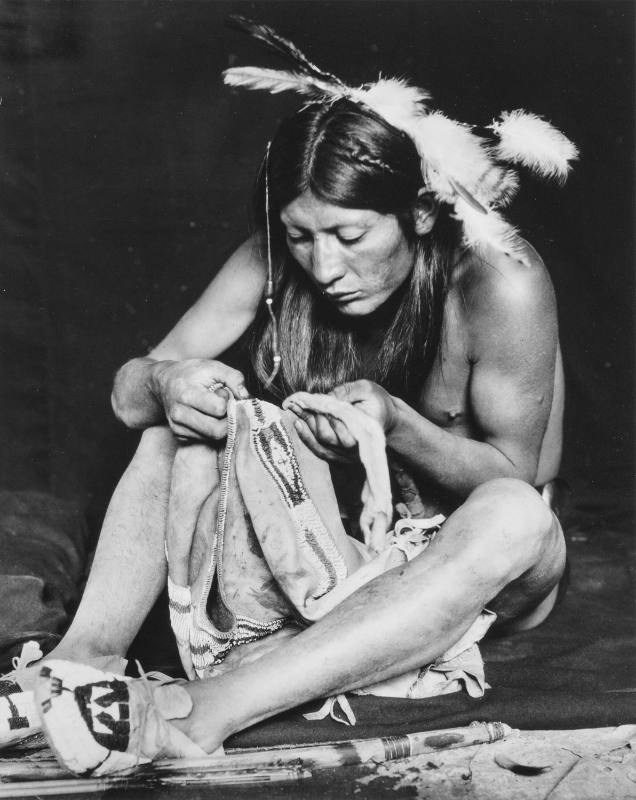 Jerry Mirabal Examining a Beaded Garment