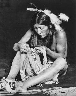 Jerry Mirabal Examining a Beaded Garment